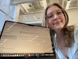 A girl smiling in front of a computer screen