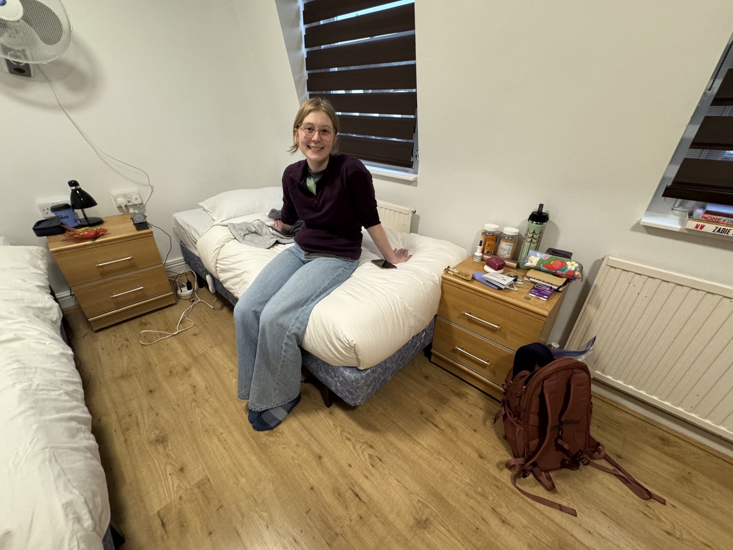 A girl sitting on a bed and smiling