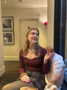A girl smiling with a croissant