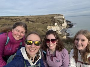 Four girls smiling at the cliffside