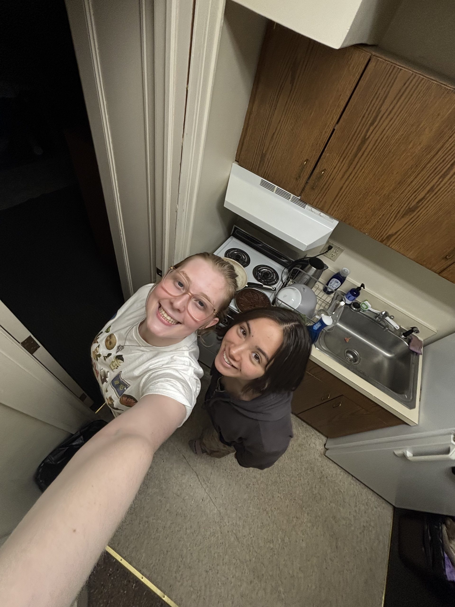Two students smiling in a kitchen