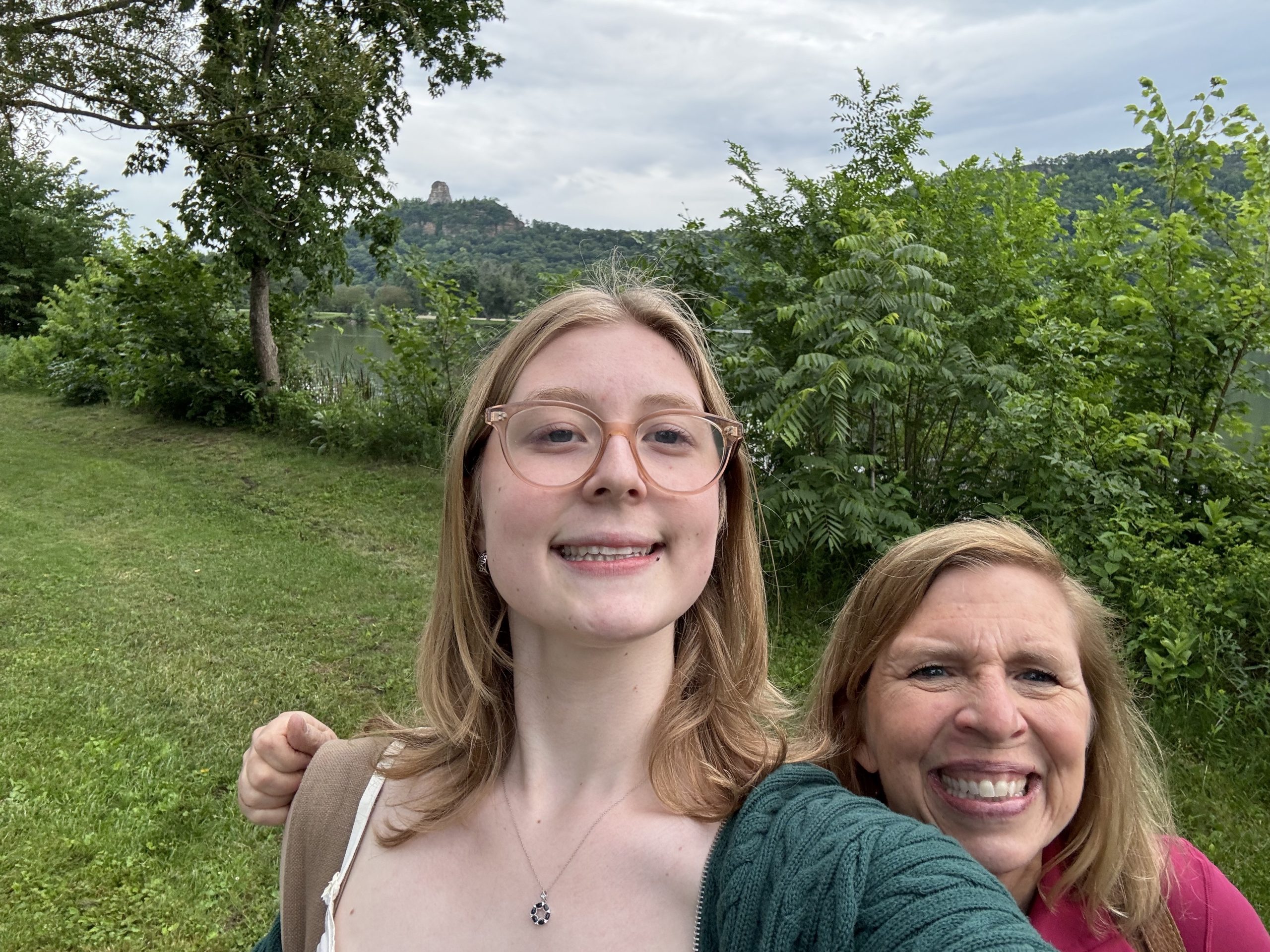 A girl and her mom smiling in Nature