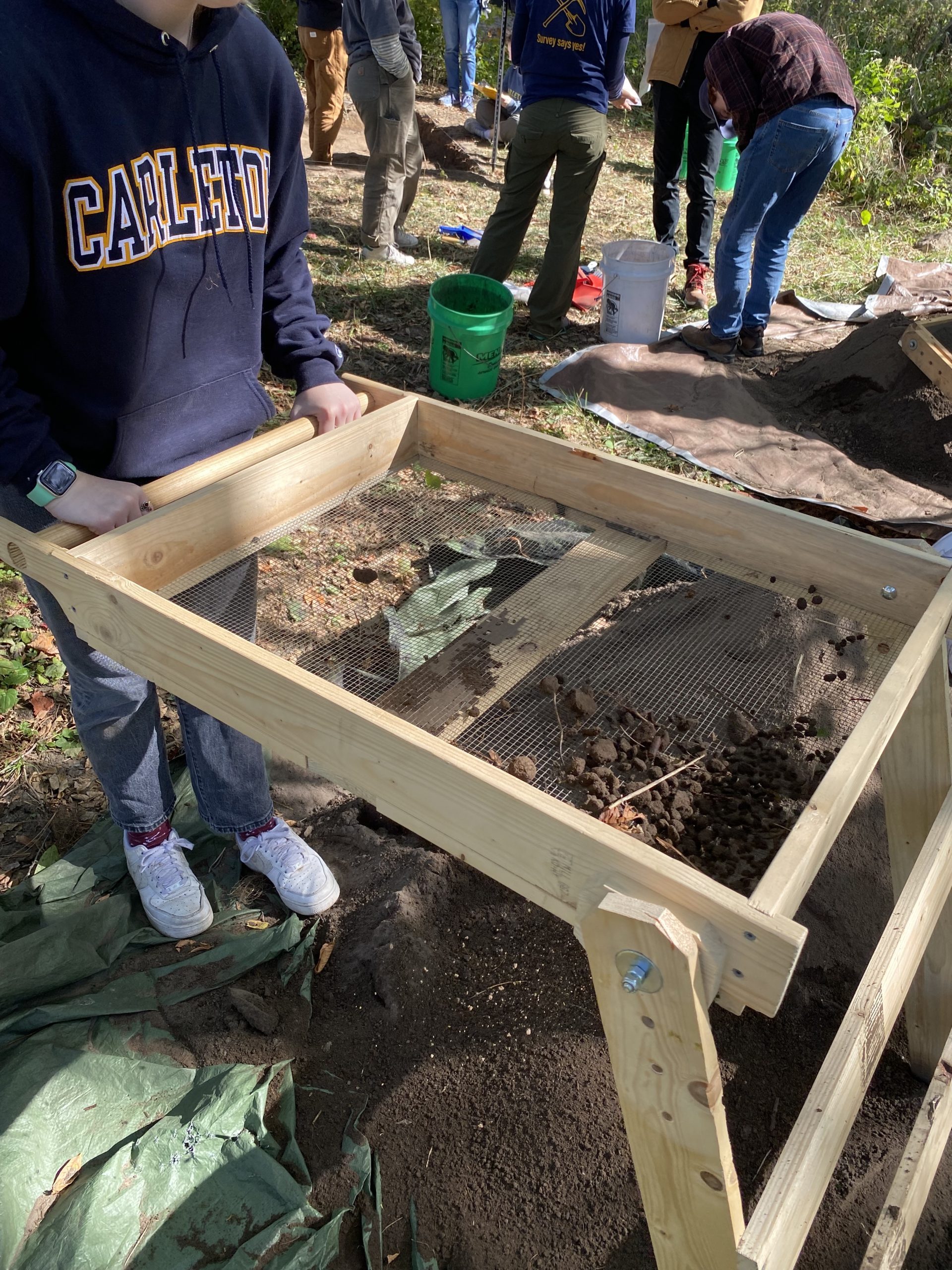 A student sifting dirt
