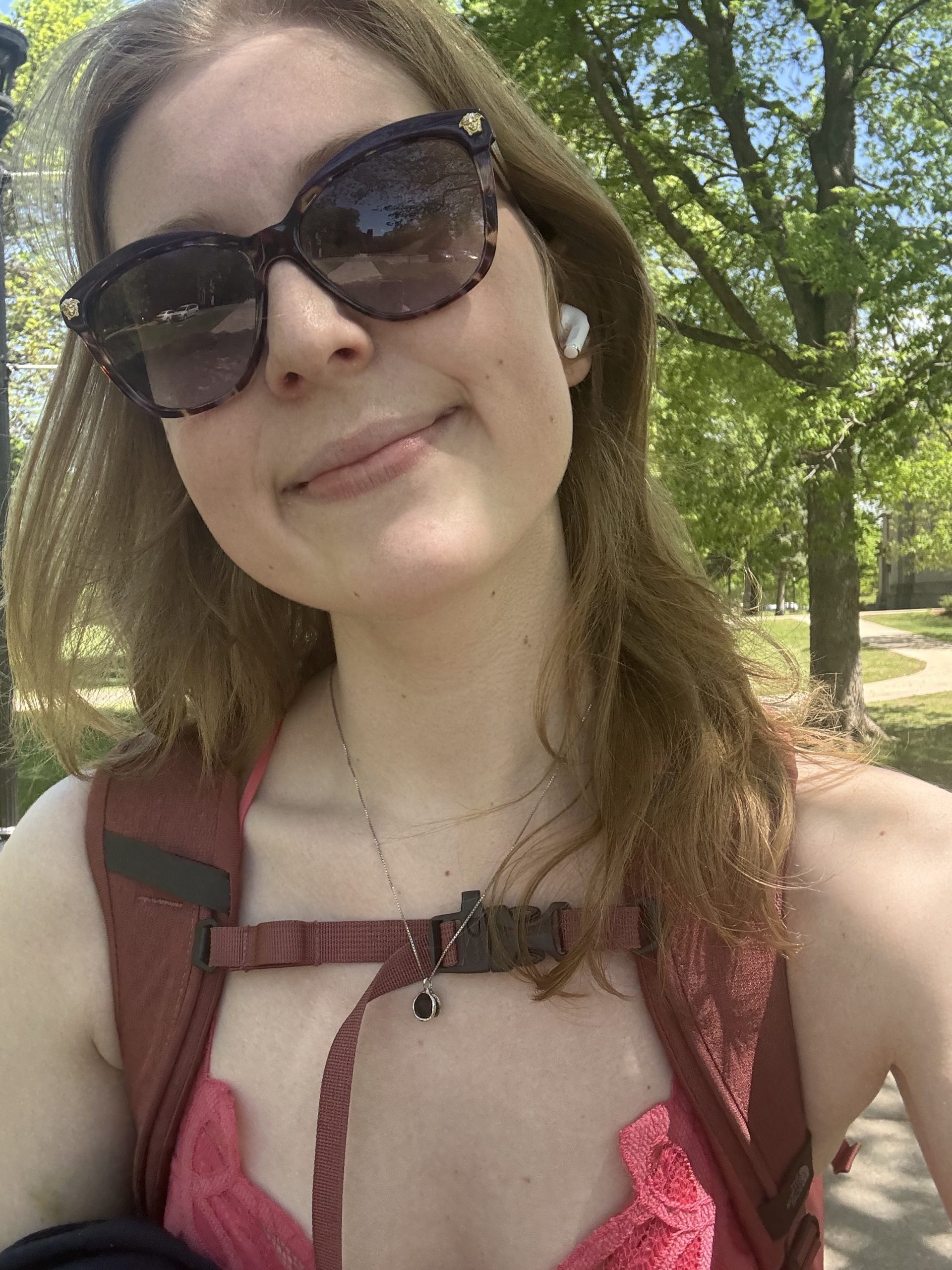 A student with sunglasses smiling at the camera