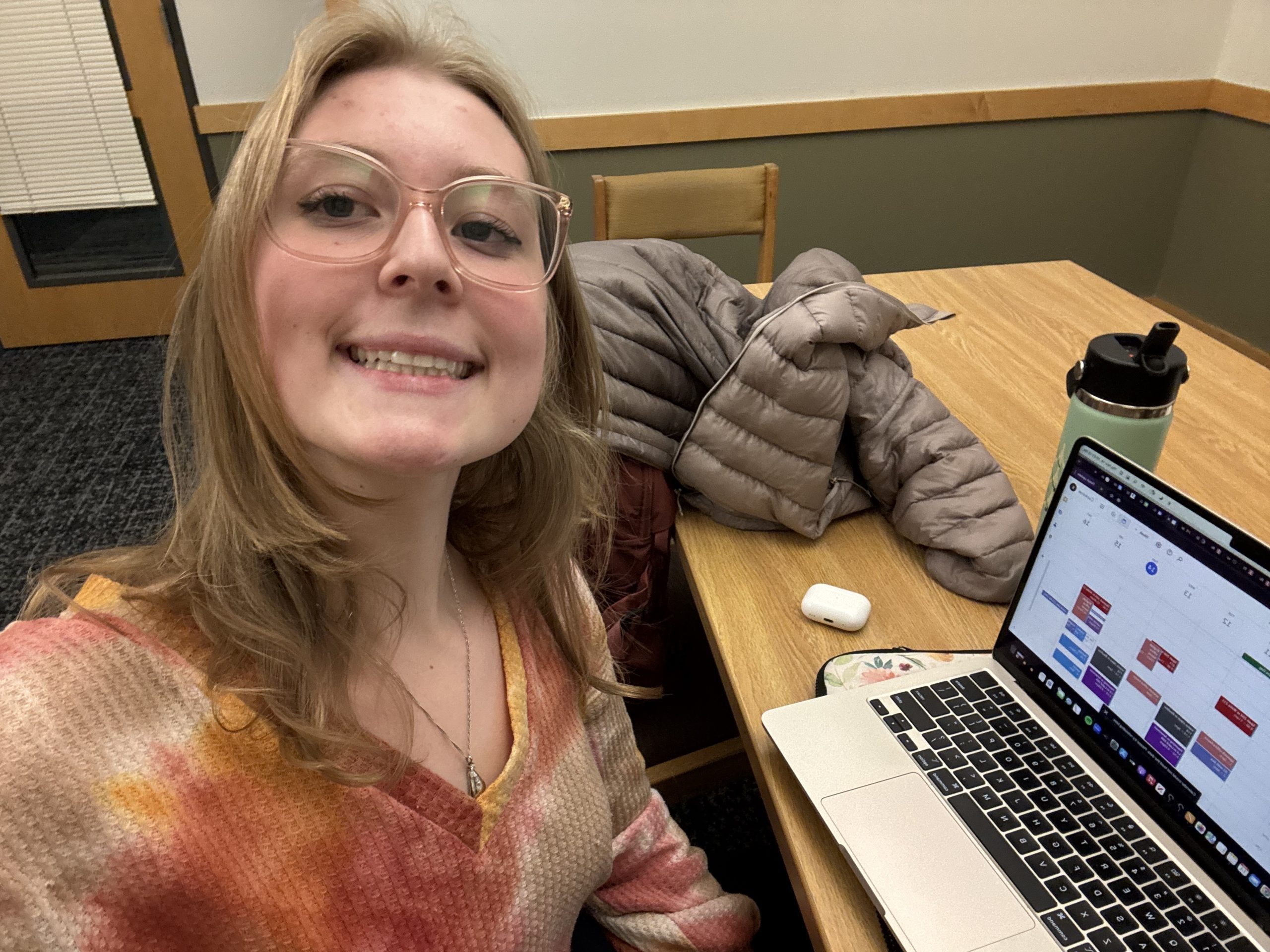 A student smiling in front of a computer