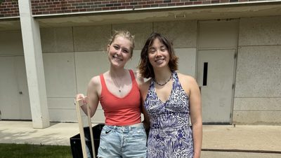 Two girls smiling and holding a mirror