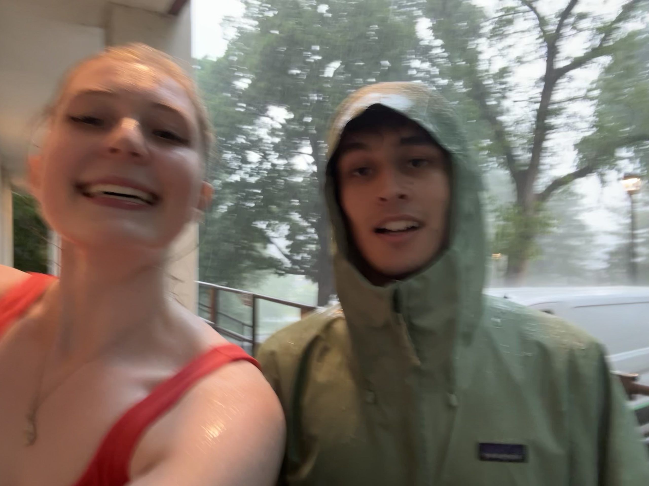 Two students smiling in the rain