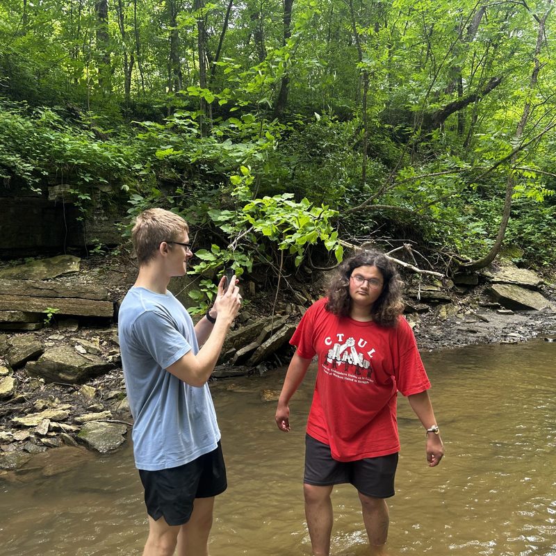 Two students standing in a river