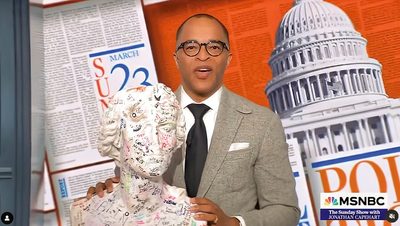 Jonathan Capehart holding a statue of Schiller