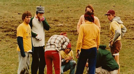 A group of students stand in a group on a frisbee field