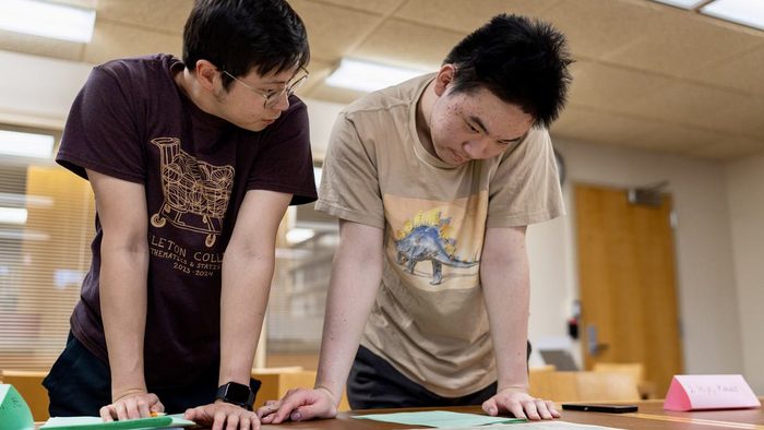 Two students looking over a map in the library