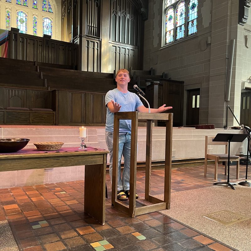 A student standing at a podium and speaking at the chapel
