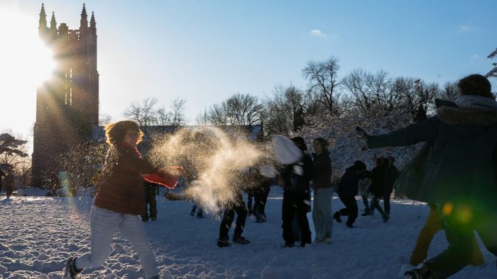 A group of students engaged in a snowball fight.