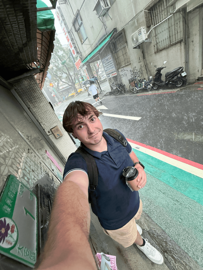 Man takes a selfie in the rain on a Taiwanese street. 