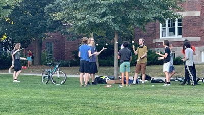Students juggle at juggling club on the mini bald spot