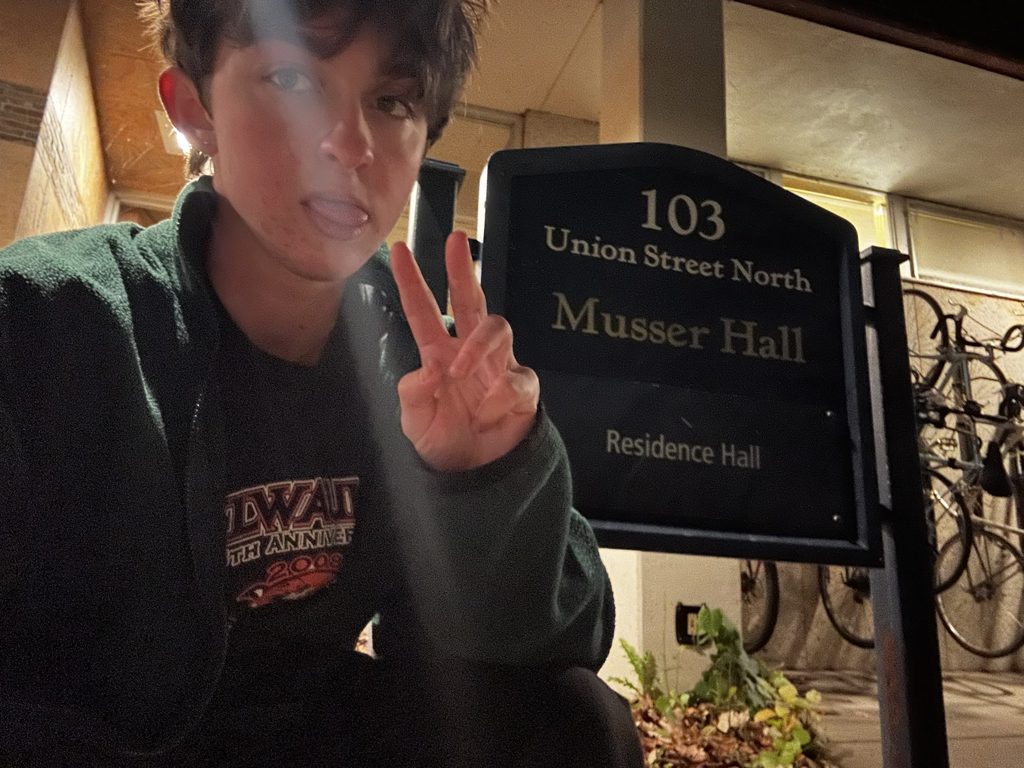 student poses in front of musser sign