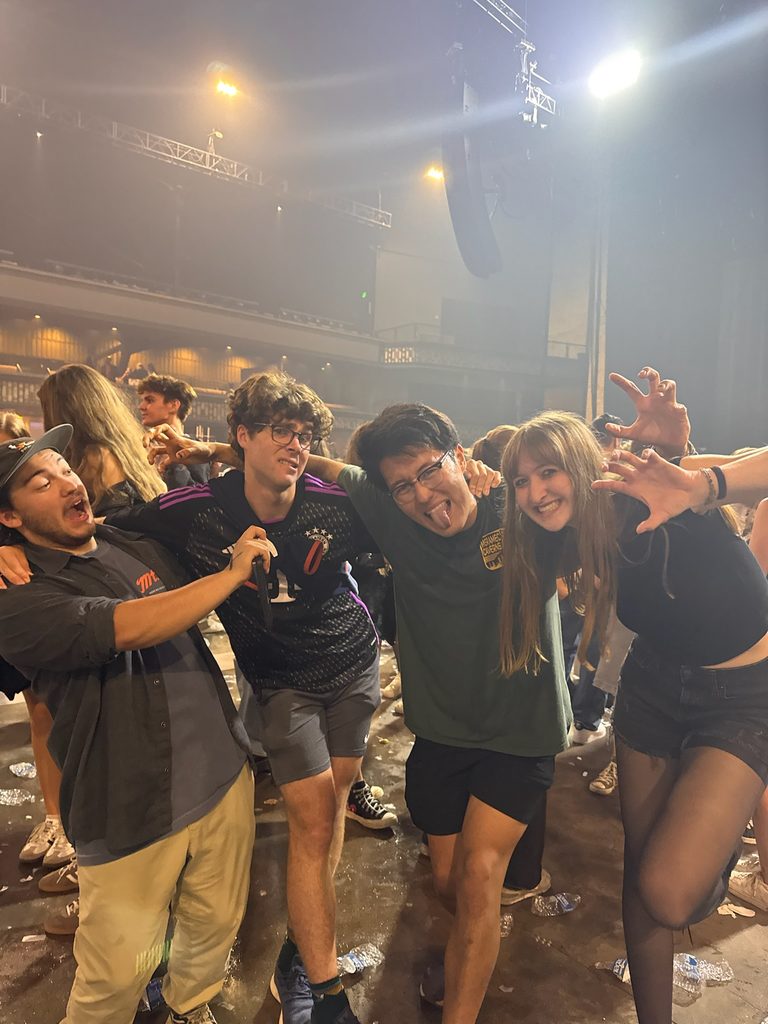 Four friends posting up for a photo after a concert