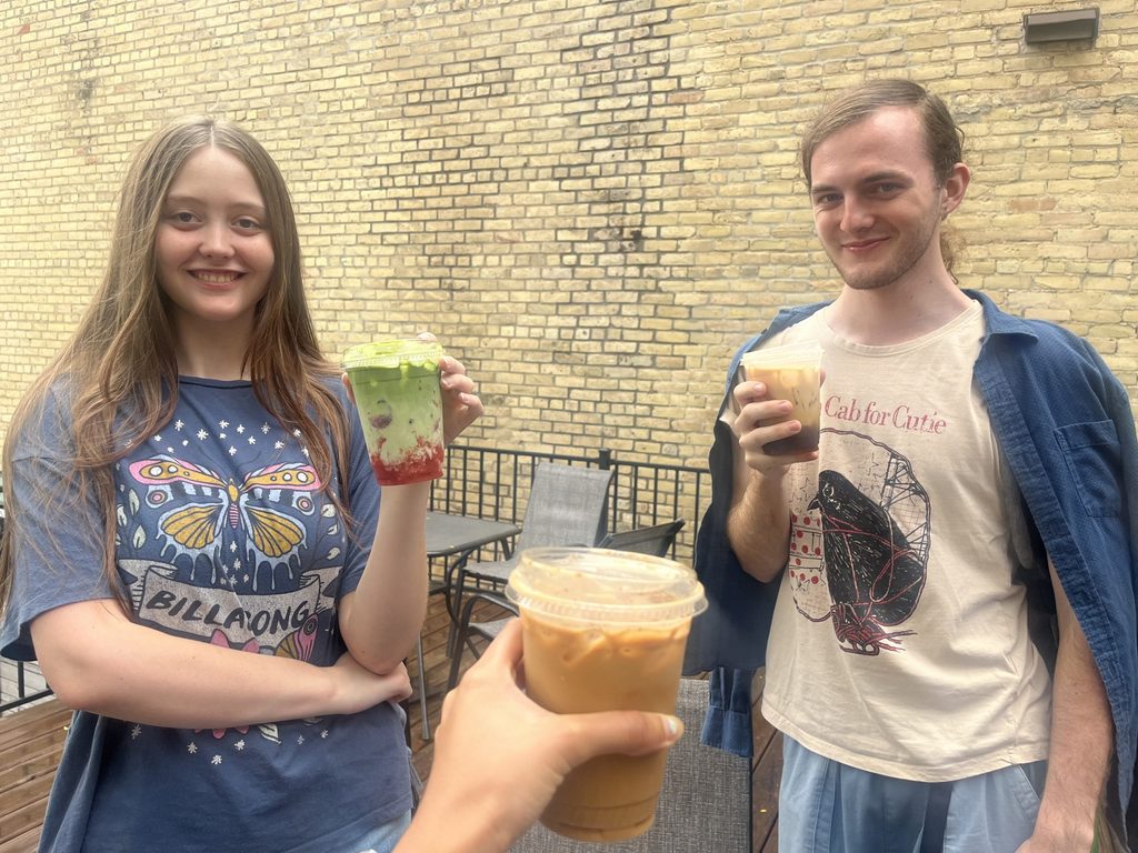 Two students stand holding iced coffee and matcha