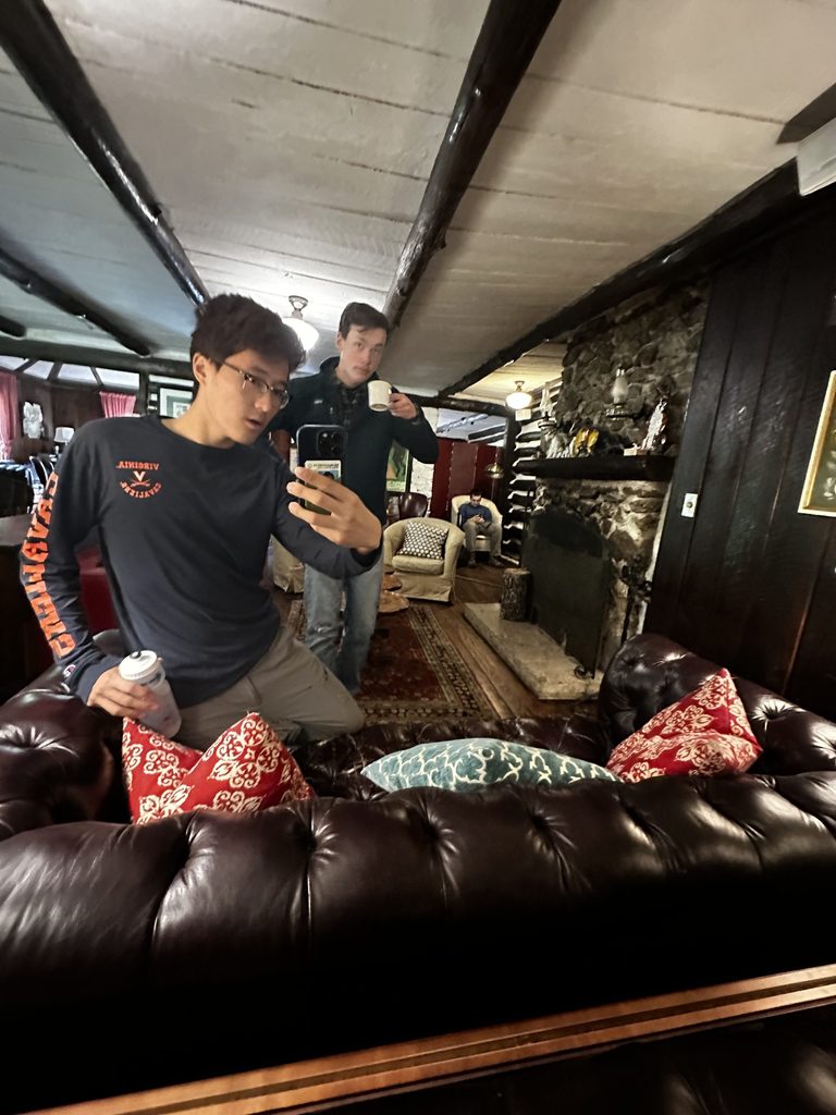 Two people taking a selfie in a mirror in a rustic lodge