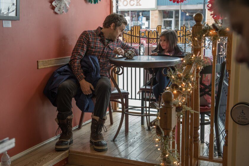 A man and child talk to each other in a coffee shop
