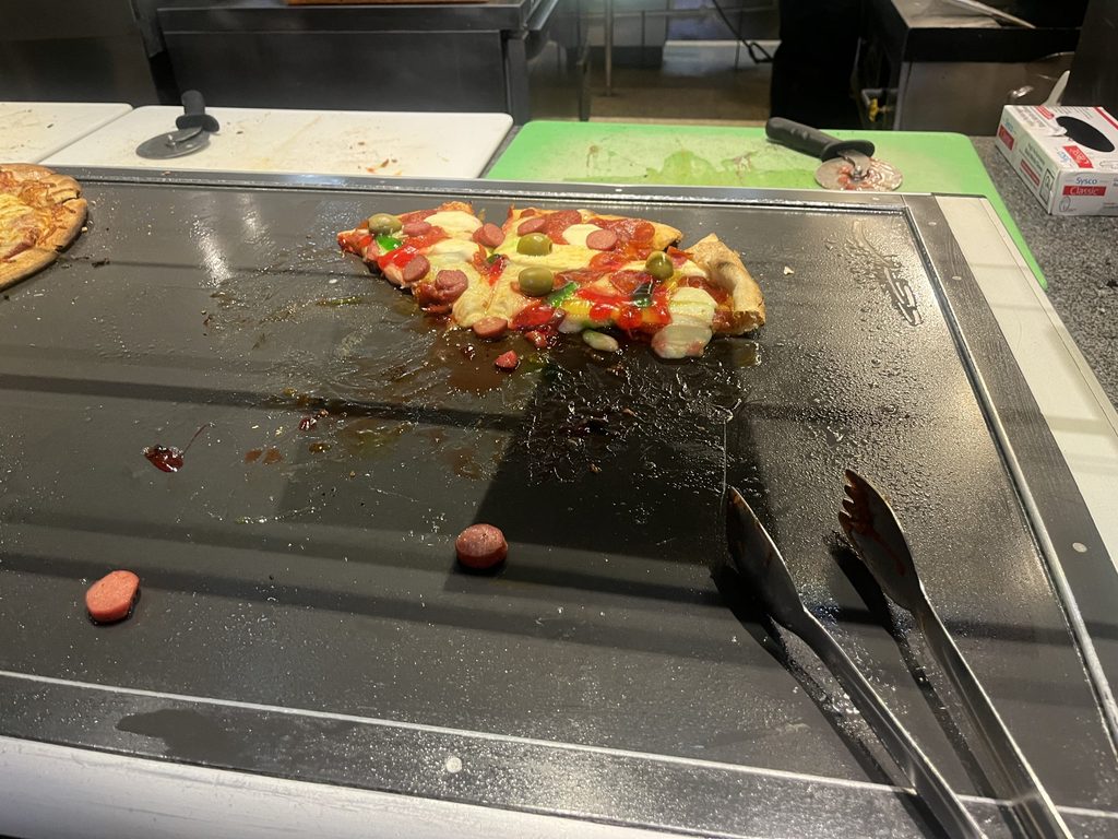 Pizza with olives, gummy worms, and hot dogs