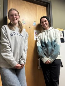 two girls posing in front of their door