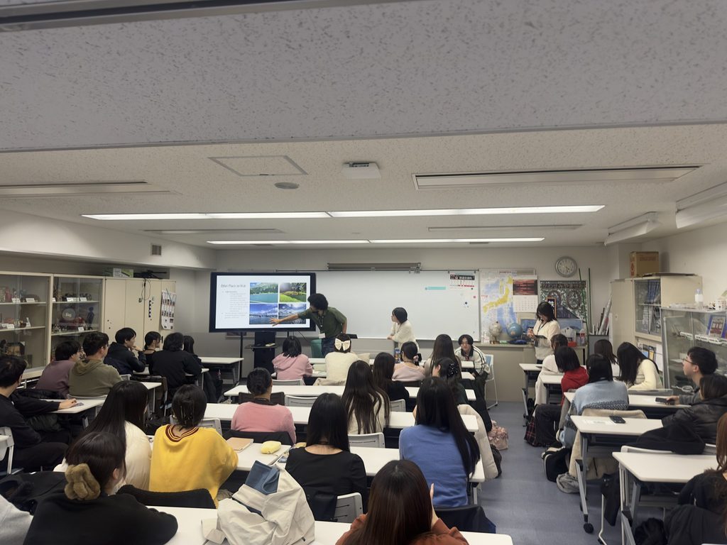 A man teaching a class in front of a full class of students