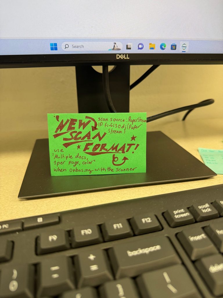 A decorative sign with information on how to scan documents behind a keyboard