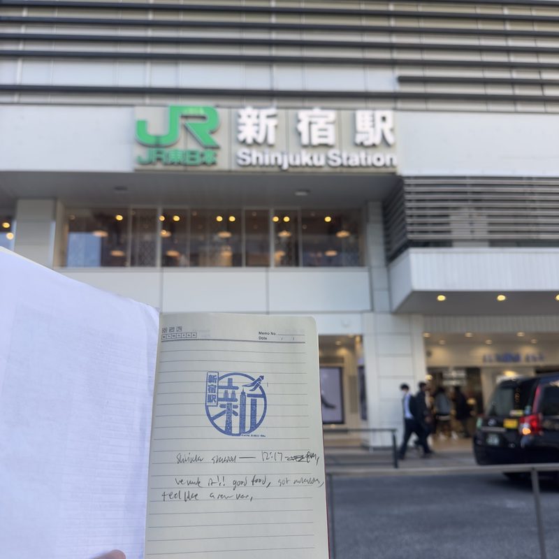 A person holding up a notebook with a stamp. 