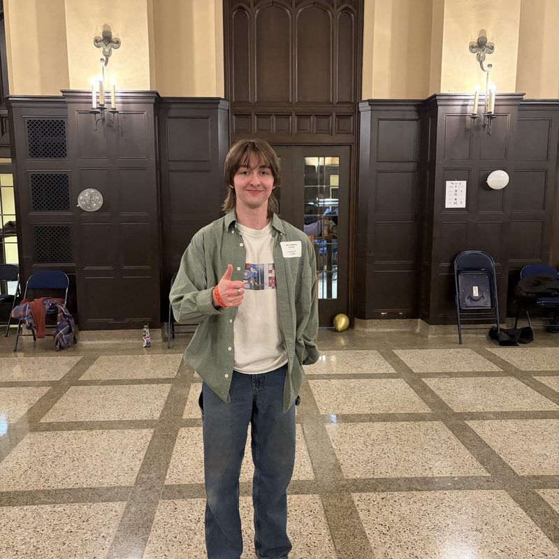 a student smiling and giving a thumbs up 