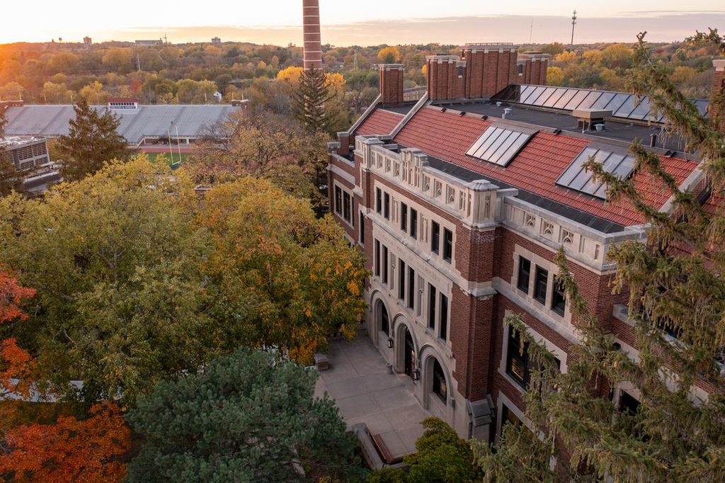 Drone/aerial photos of campus and campus buildings in the evening during peak fall colors.