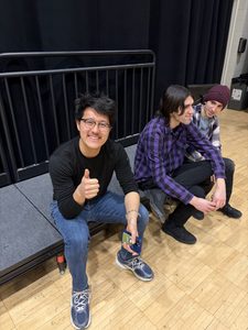a student sitting and smiling with a thumbs up