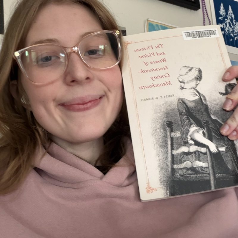 A student smiling with a book