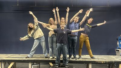 a group of students with their hands in the air