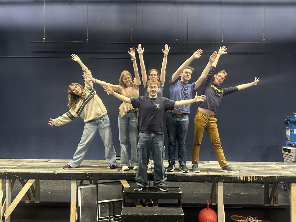 a group of students with their hands in the air