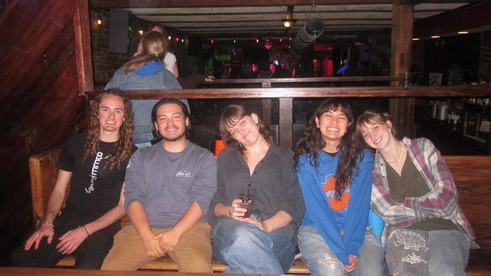 Four people smiling near a pool table