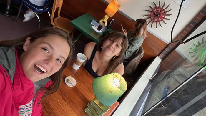 Two people taking a selfie at a coffee shop