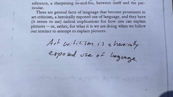 A printed paper with a hand-written note on it that reads "art criticism is a heroically exposed use of language."