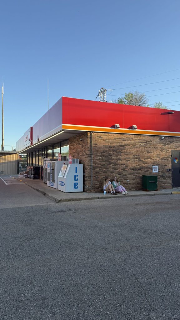 two girls outside a gas station