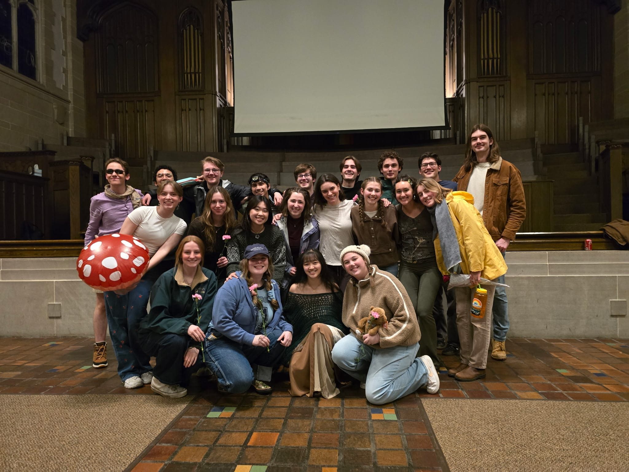 A group of smiling students dressed in camping gear.