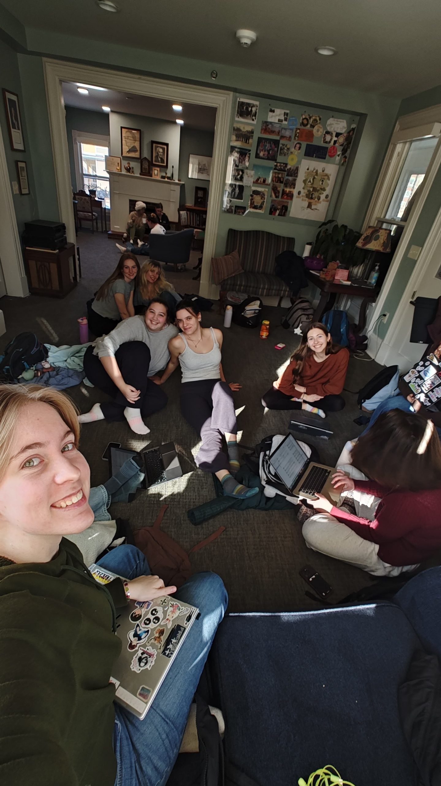 A group of girls sitting down and smiling at the camera.