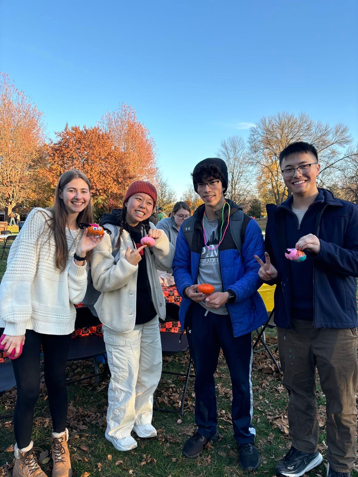 four people with painted pumpkins