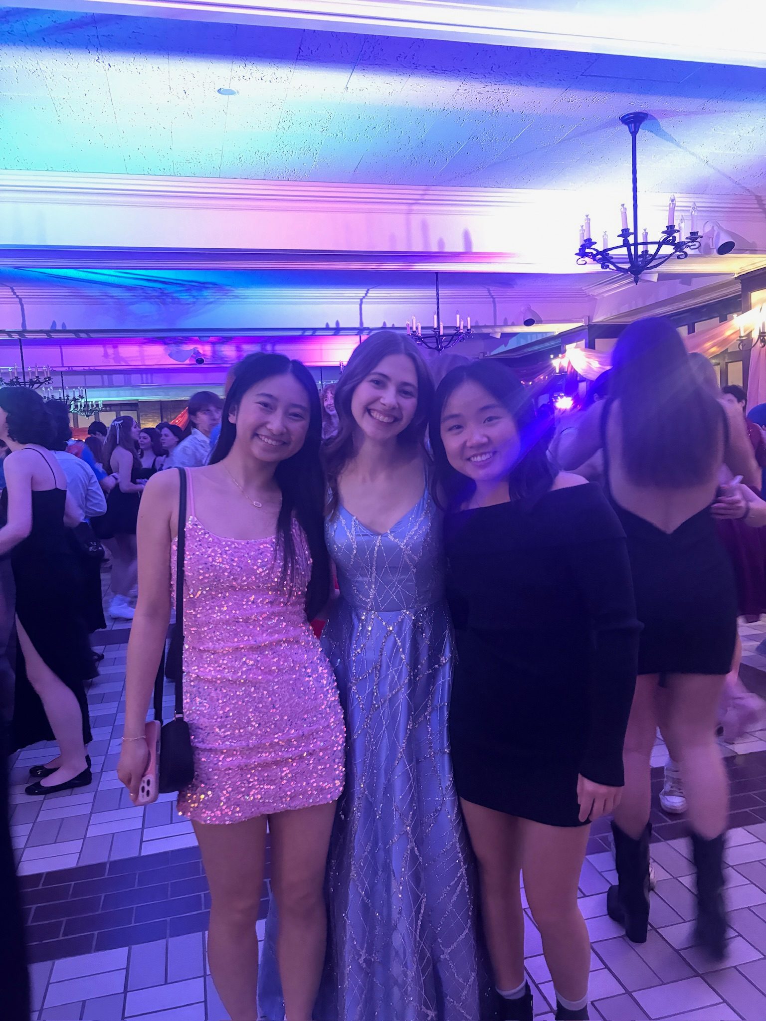 three girls in dresses around bright lights