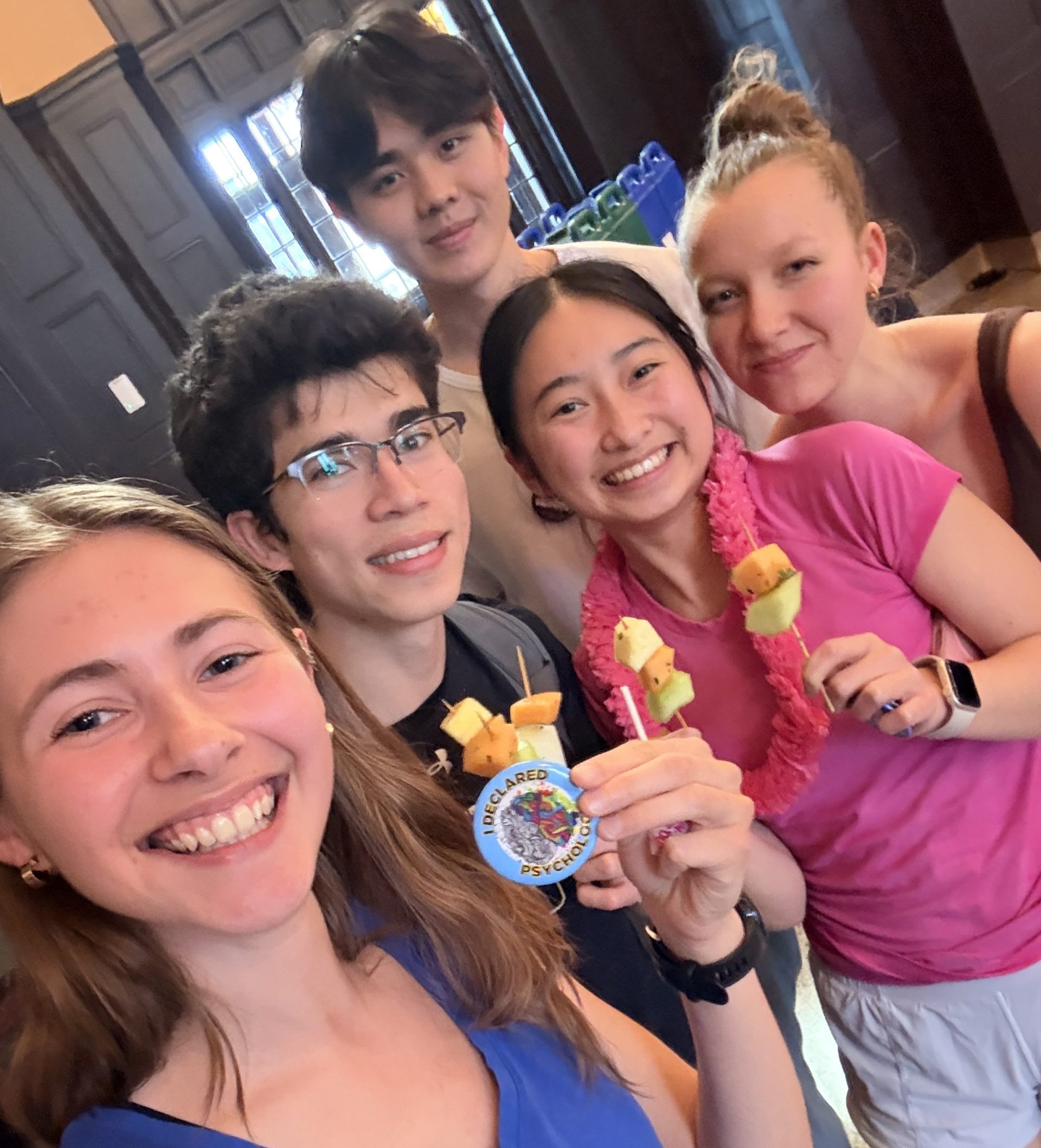 five friends smiling with buttons and fruit