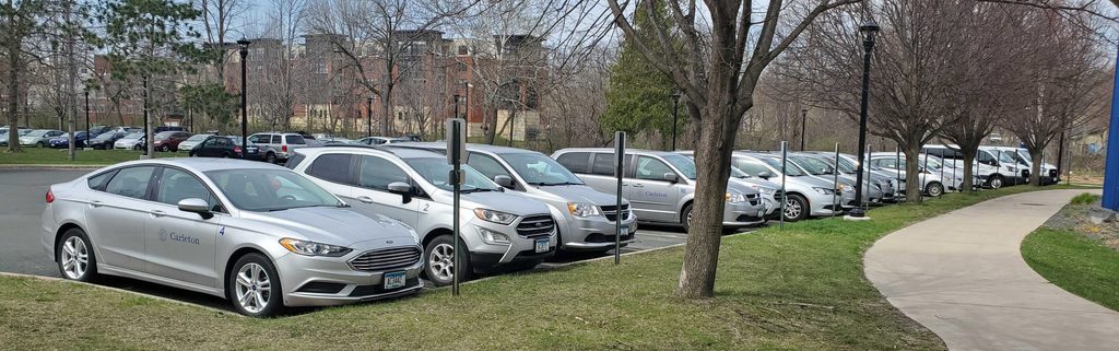 row of fleet vehicles parked in a parking lot