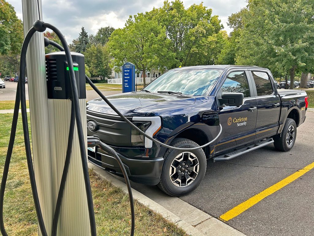A Carleton security truck plugged into a charging station