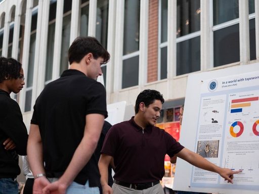student pointing to a chart on a poster