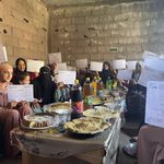 Moroccan women holding signs around table