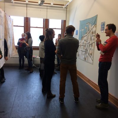 Students gather in a small room with artwork on the walls