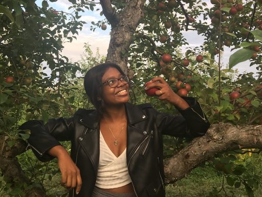 Bethstyline Chery stands beneath an apple tree